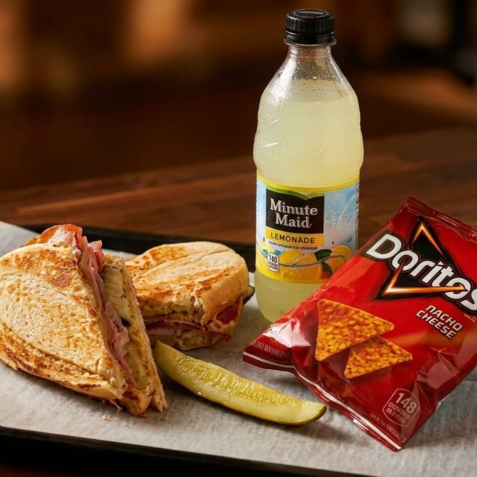 A sandwich, pickle spear, bag of Doritos, and Minute Maid lemonade on a black tray.