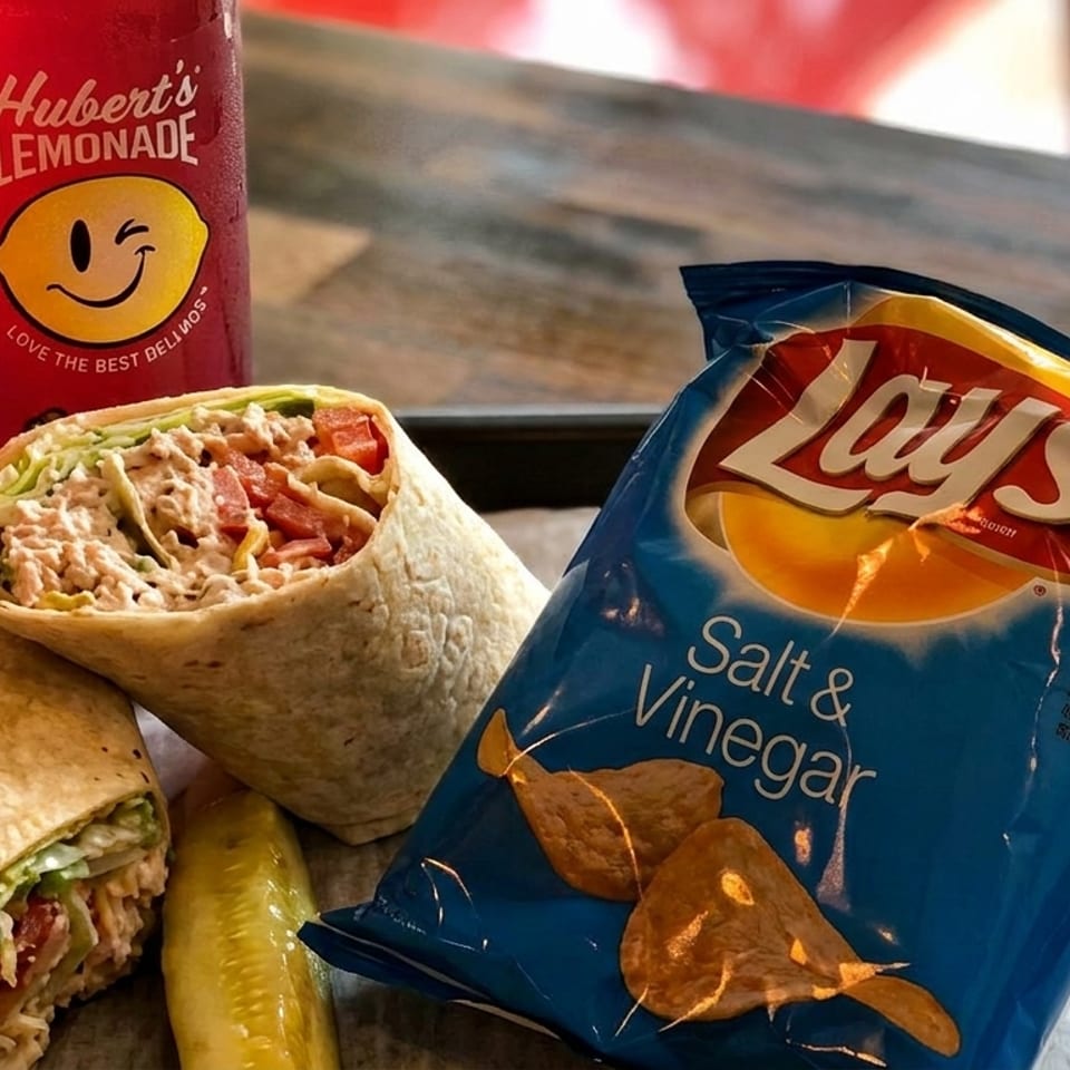 Two wraps, a pickle spear, a bag of Lay's Salt & Vinegar chips, and Hubert's Lemonade.